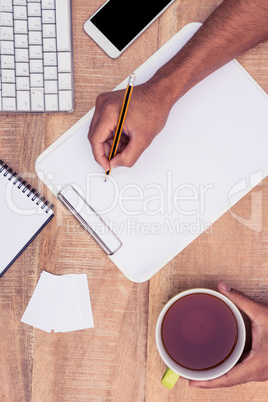 Cropped image of businessman writing on notebook