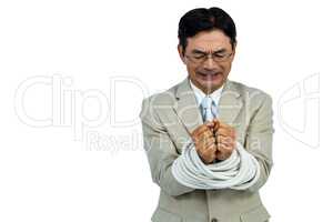Asian businessman tied up in rope