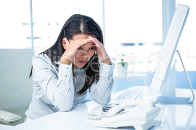 Unsmiling businesswoman with hands on head