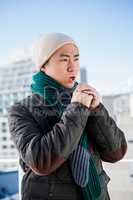 Man in warm clothing blowing his hands