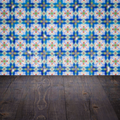 Wood table top and blur vintage ceramic tile pattern wall