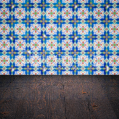 Wood table top and blur vintage ceramic tile pattern wall