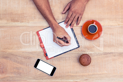 Man writing on diary at table