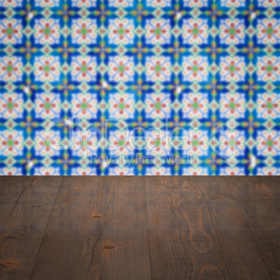 Wood table top and blur vintage ceramic tile pattern wall