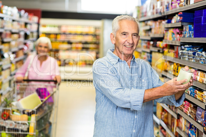 Senior man looking at canned food