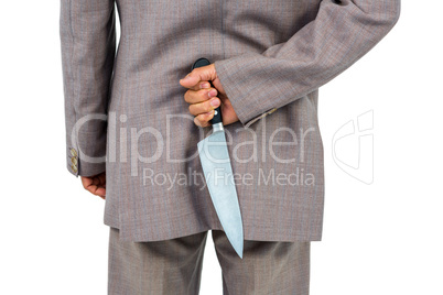 Businessman holding knife behind his back