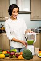 Smiling brunette preparing smoothie