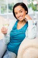 SMiling brunette holding glass of white wine