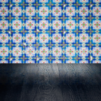 Wood table top and blur vintage ceramic tile pattern wall