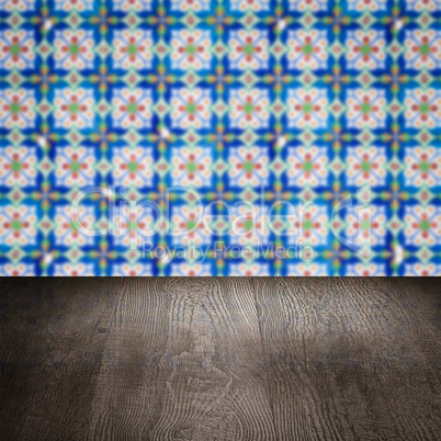 Wood table top and blur vintage ceramic tile pattern wall