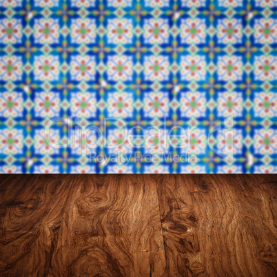 Wood table top and blur vintage ceramic tile pattern wall