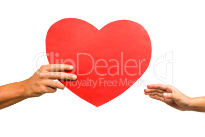 Cropped hand of man giving heart shaped paper to woman