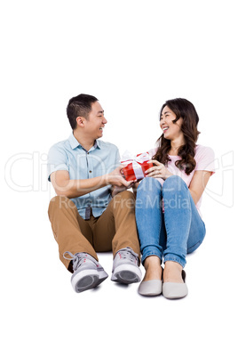 Happy couple with gift looking at each other