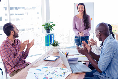 Business people applauding for female coworker