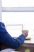 Business professional holding coffee cup at desk in office