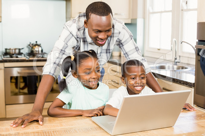 Happy family using laptop in the kitchen