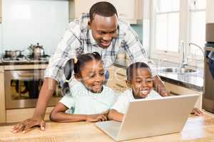 Happy family using laptop in the kitchen