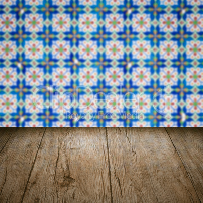 Wood table top and blur vintage ceramic tile pattern wall