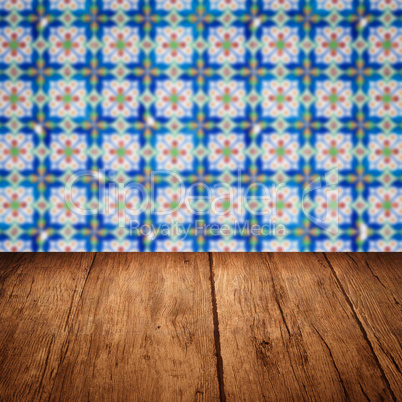 Wood table top and blur vintage ceramic tile pattern wall