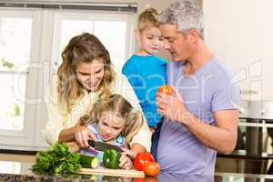Happy family slicing vegetables