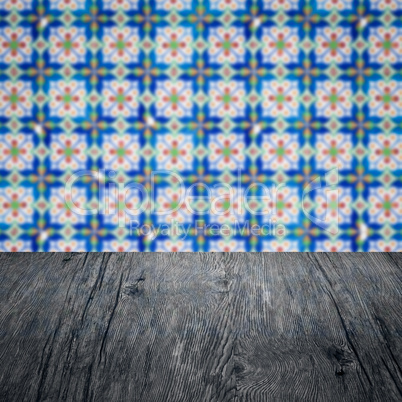 Wood table top and blur vintage ceramic tile pattern wall