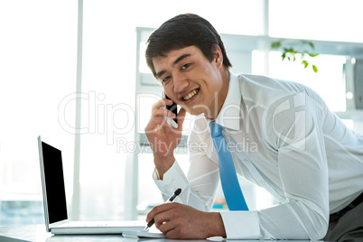 Smiling asian businessman writing notes