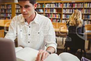 Focused student using his laptop while working