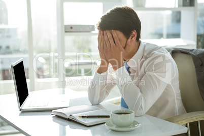 Tired asian businessman working at his desk