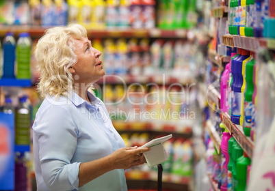 Woman with pad shopping for household detergents