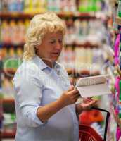 Woman using tablet PC in household chemicals section