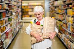 Portrait of smiling senior woman with grocery bags