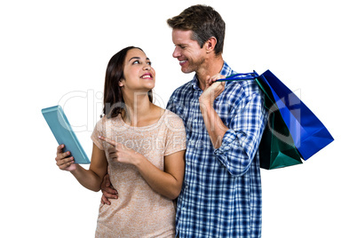Couple with shopping bags using digital tablet
