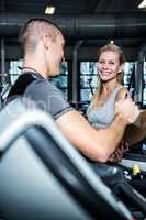 Smiling woman with trainer using treadmill
