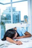 Tired businesswoman sleeping at her desk