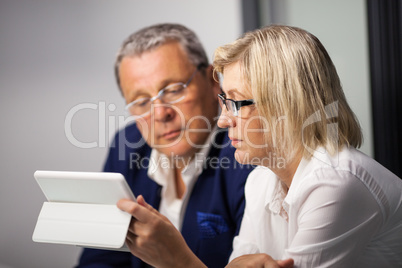 Mature businesspeople working with tablet PC