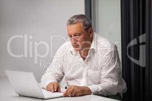 Senior businessman working with laptop in office