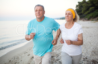 Senior couple jogging on the coast