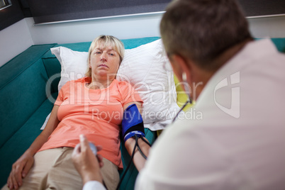 Doctor checking womans blood pressure