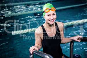 Smiling swimmer woman getting out of the swimming pool