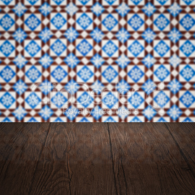 Wood table top and blur vintage ceramic tile pattern wall