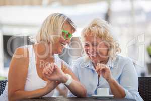 Senior women laughing in street cafe