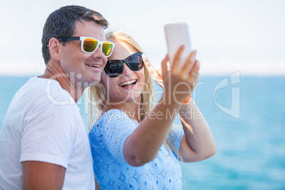 Happy summer selfie of young couple in sunglasses