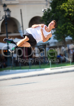 Young man performing somersault in the street