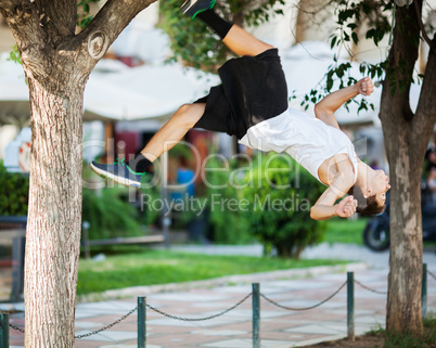 Young athlete doing extreme acrobatics outdoor
