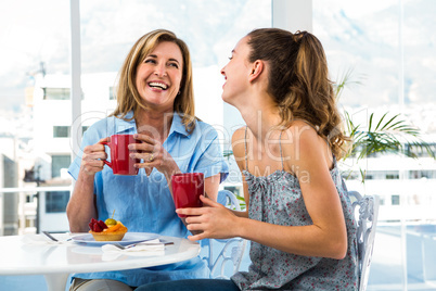 Mother and daughter eat breakfast