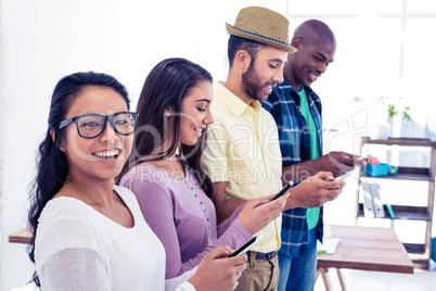 Portrait of businesswoman using phone with colleagues