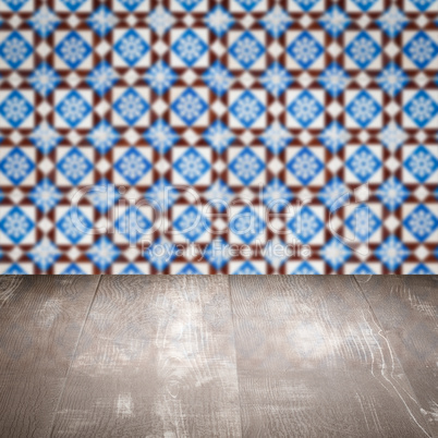 Wood table top and blur vintage ceramic tile pattern wall