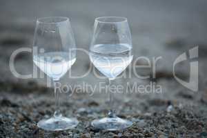 Two glasses of water on the beach