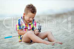 Happy boy with selfie stick and cell at the seaside