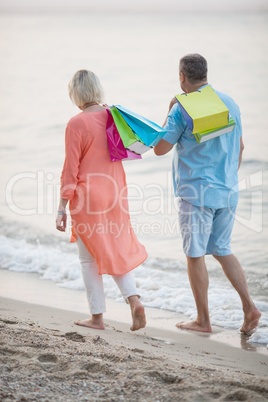Couple walking on the beach after vacation shopping